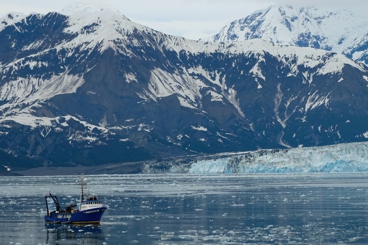a boat in the water with a mountain in the background